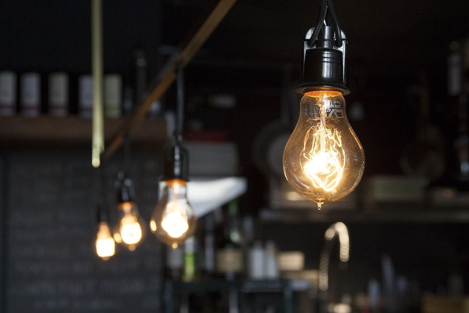 A row of light bulbs hanging from the ceiling in a dark room.
