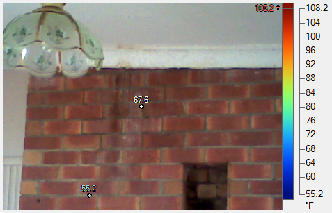 A picture of a brick wall with a thermometer on it