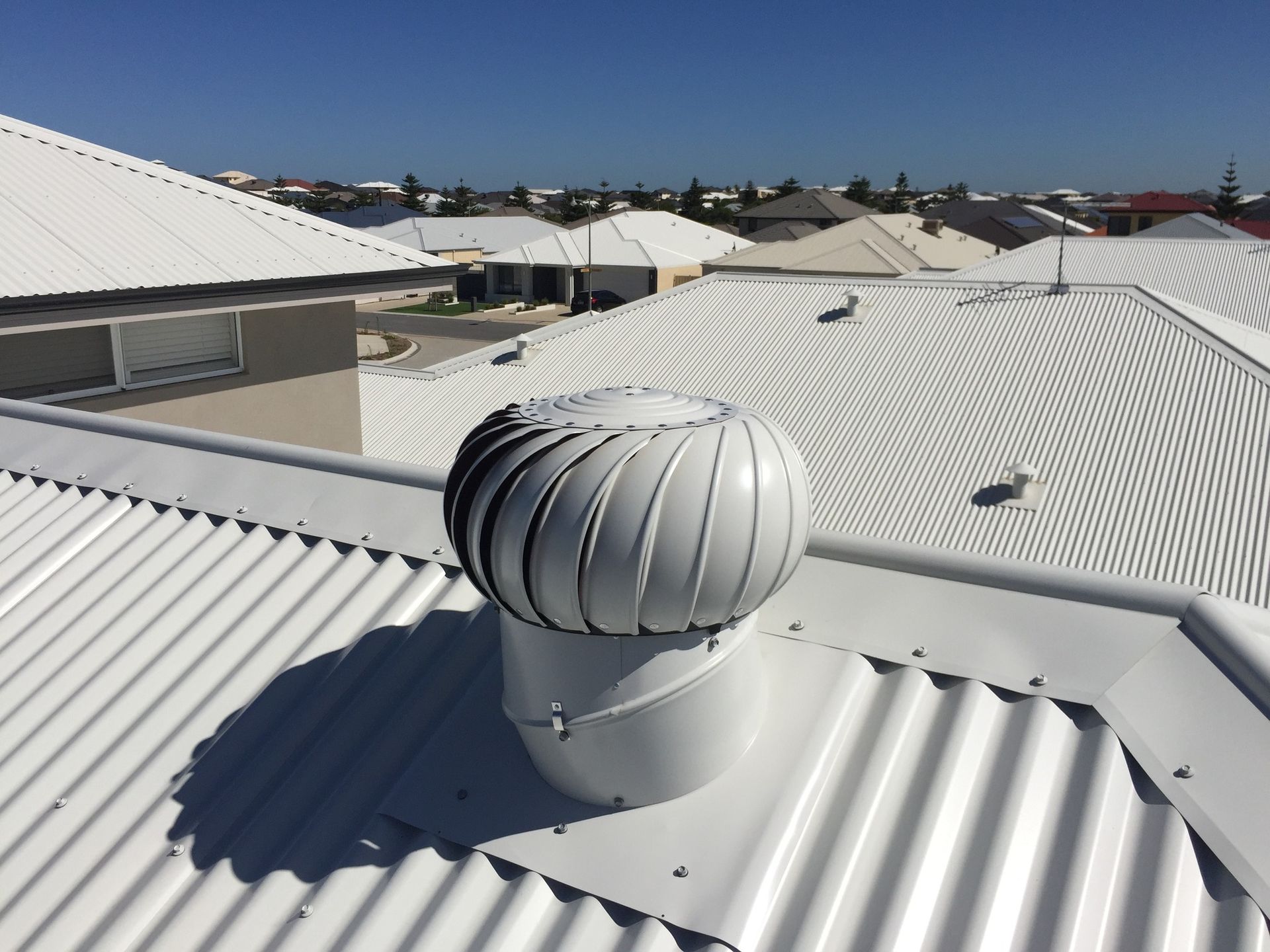 Black roof vent with fan and protective cover.