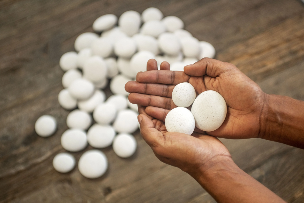 A person is holding a pile of white rocks in their hands.