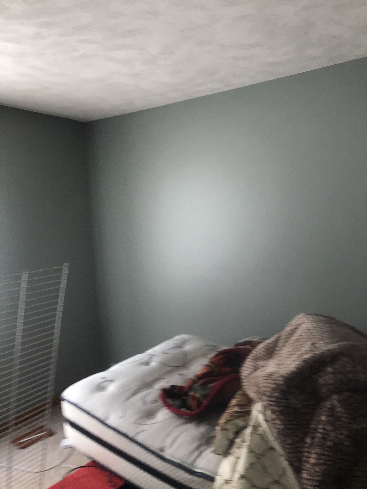A bedroom with a mattress and a blanket on it.