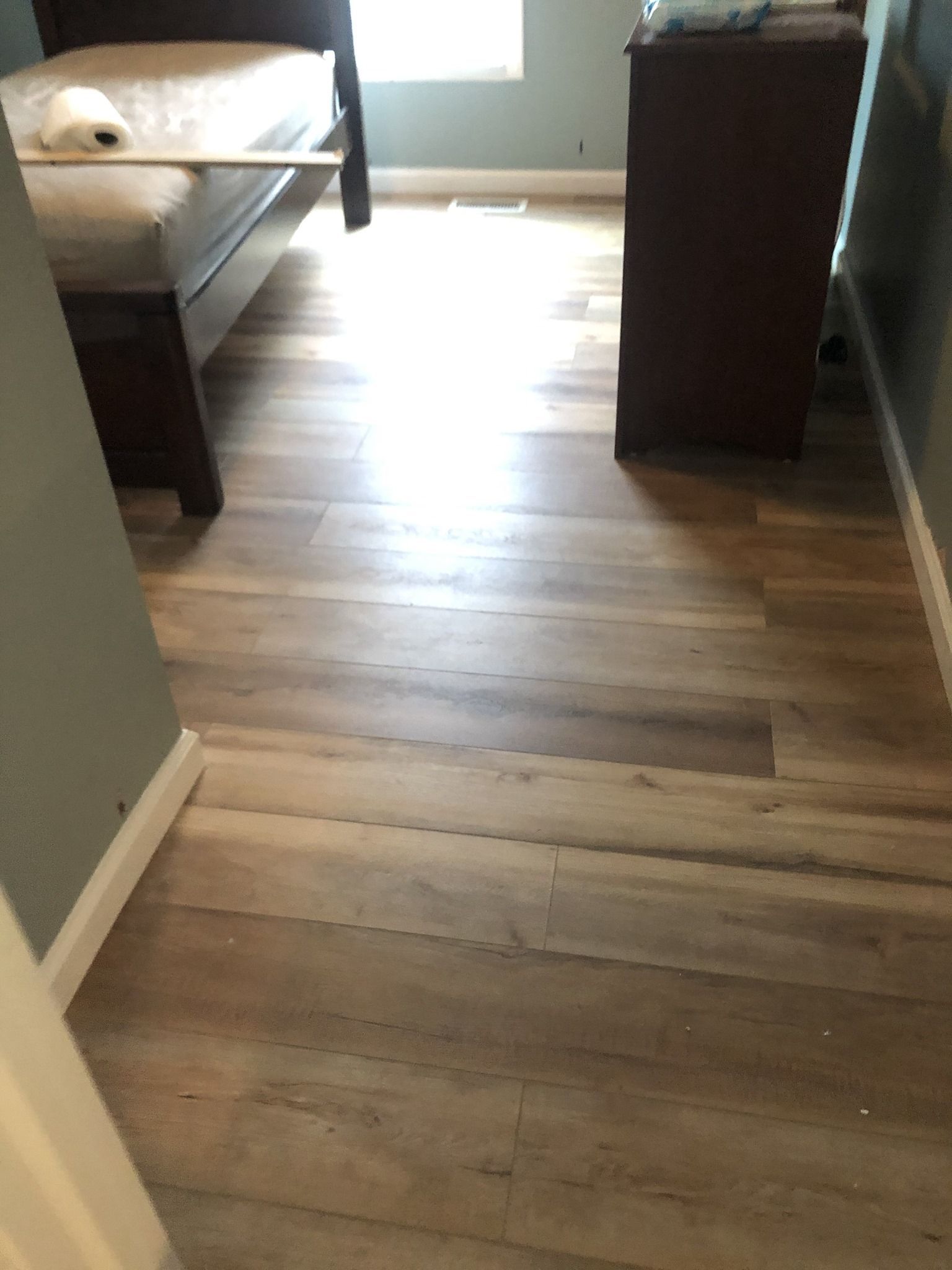 A bedroom with a wooden floor and a bed.