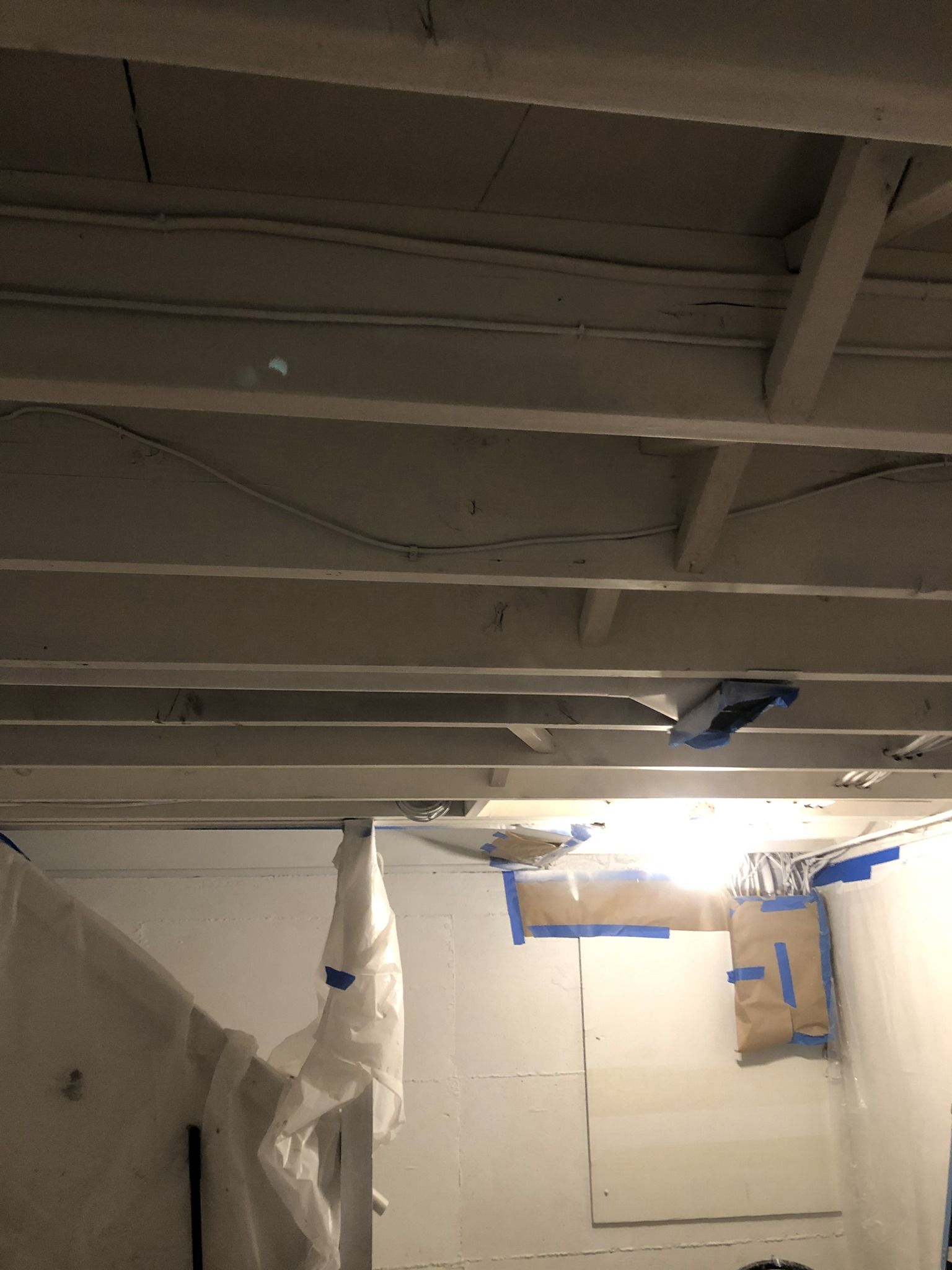 A room with a ceiling that is being painted white