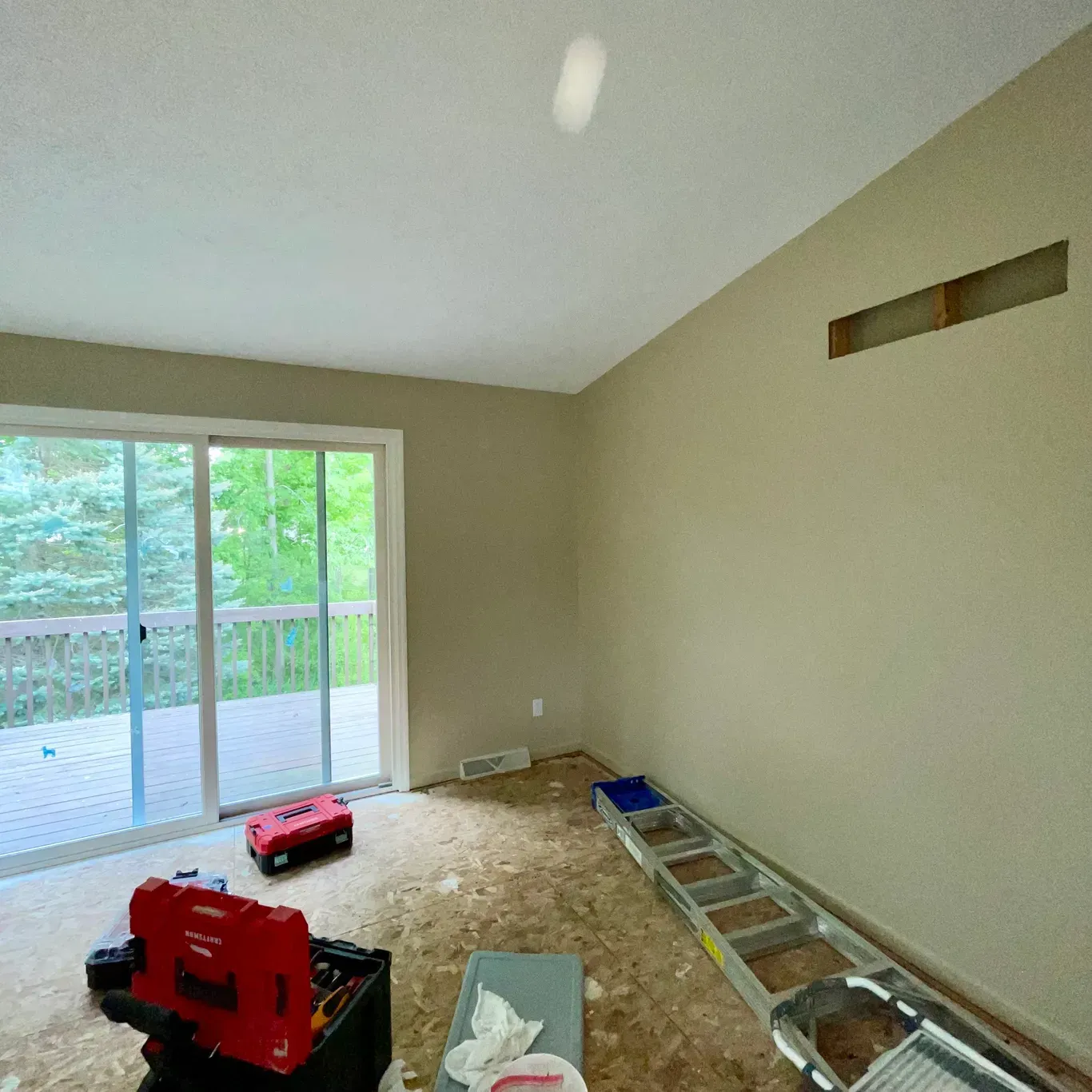 An empty room with a red toolbox and a ladder