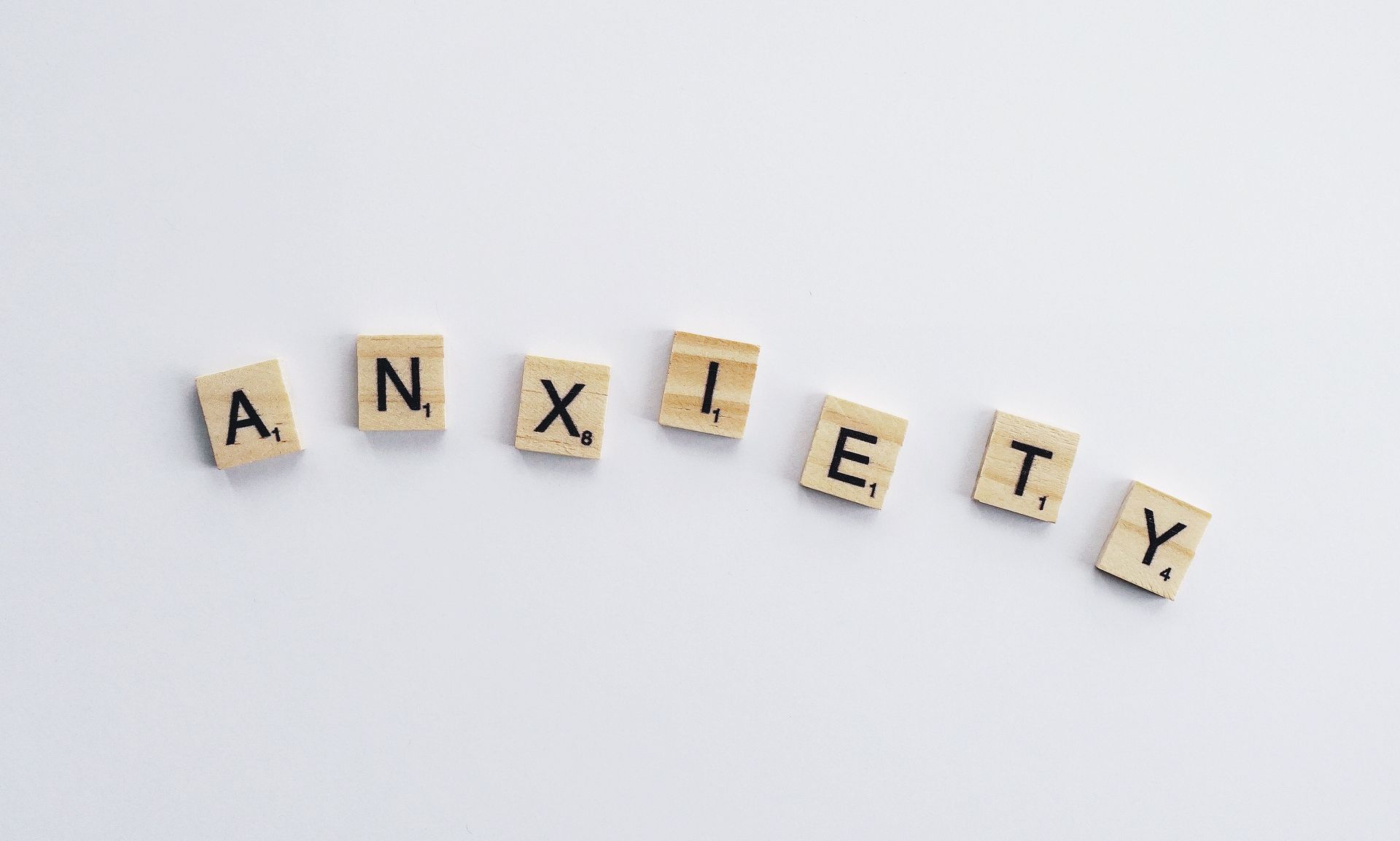 Scrabble tiles spelling “ANXIETY” on a light background