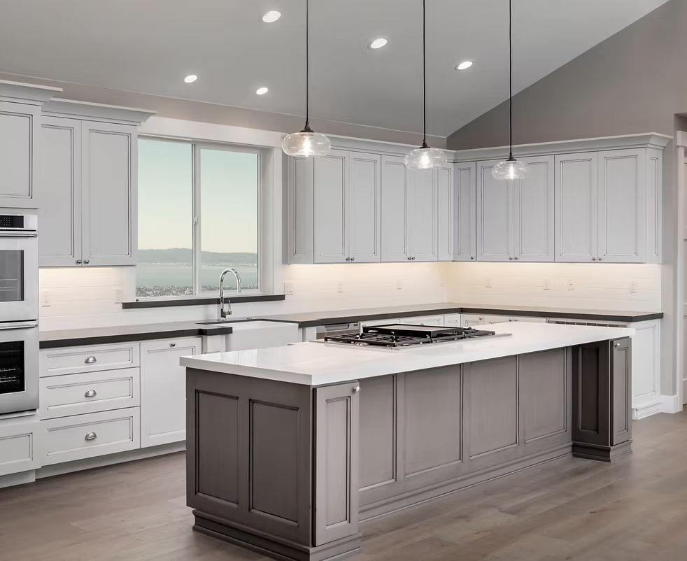 A kitchen with high quality white shaker framed cabinets and quartz countertops.