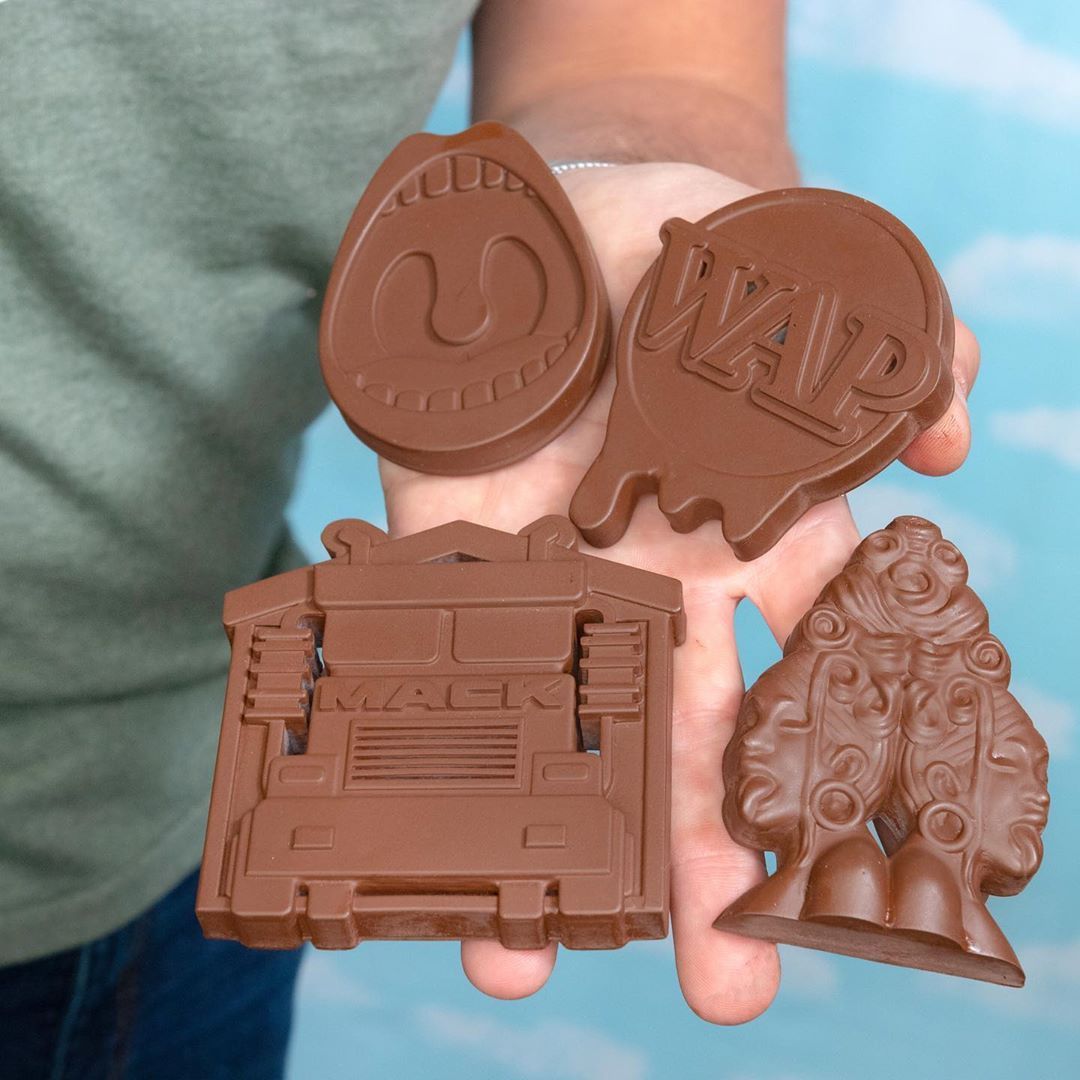 A chef mholding 4 custom made chocolate