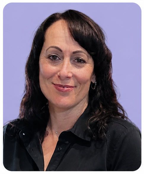 Portrait of a smiling woman with dark hair against a light purple background