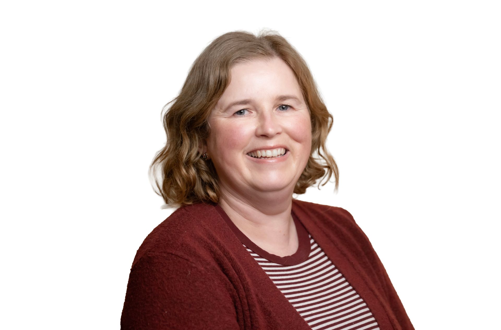 Smiling woman in a maroon cardigan and striped shirt against a white background