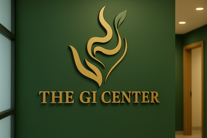 Gold logo The GI Center on a green wall. Includes a stylized flame and leaf design.