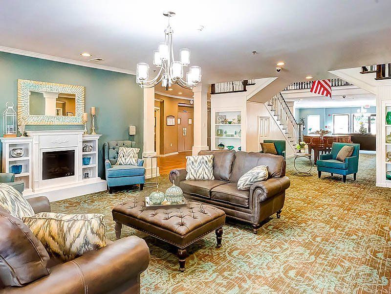 Lounge area with fireplace, sofas, armchairs, and a patterned rug.