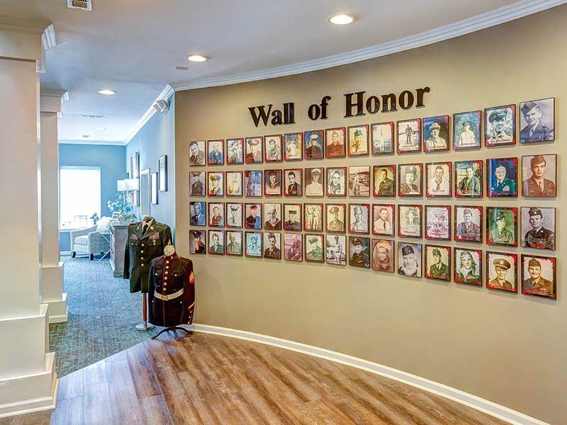 Wall of Honor with portraits, military uniforms, and text on a beige wall.