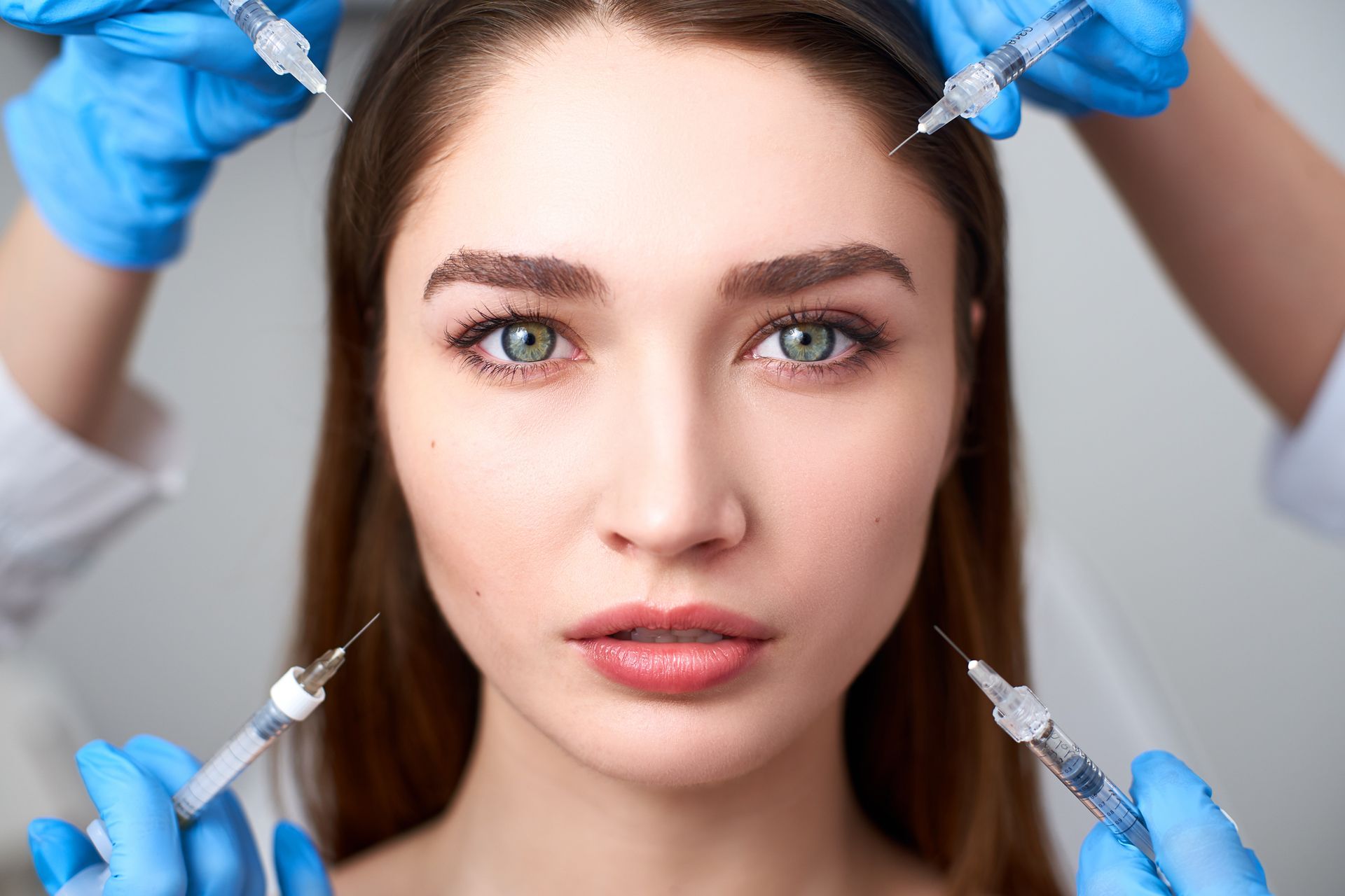 A woman is getting a botox injection in her face.