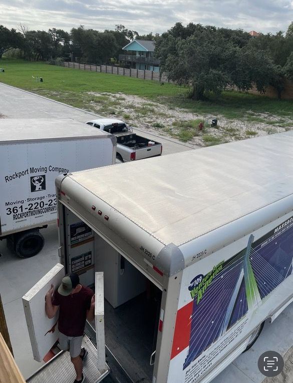 Two moving trucks parked outside, a person loading furniture.