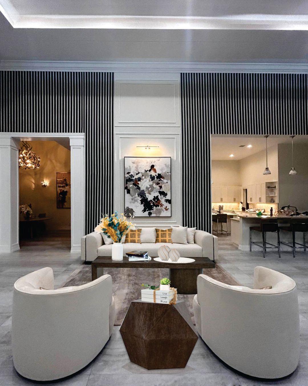 A living room with a couch , two chairs , a coffee table and a painting on the wall.