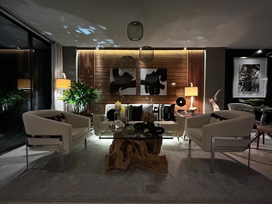 A living room with two chairs , a coffee table , and a couch.