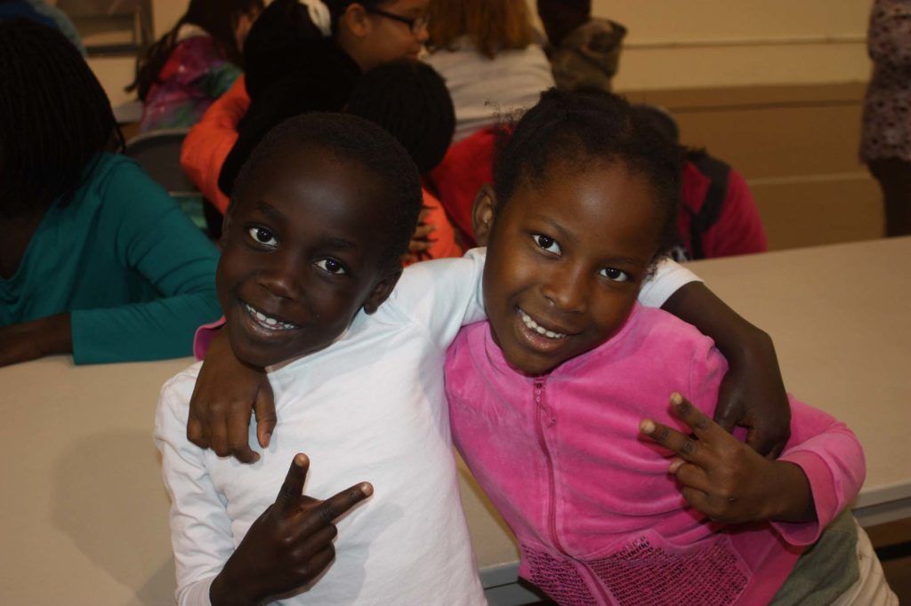 A boy and a girl are posing for a picture together.