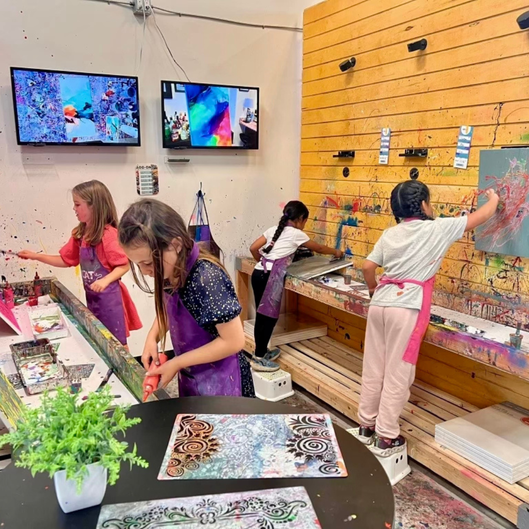 a woman is making a frame with her hands covered in paint .