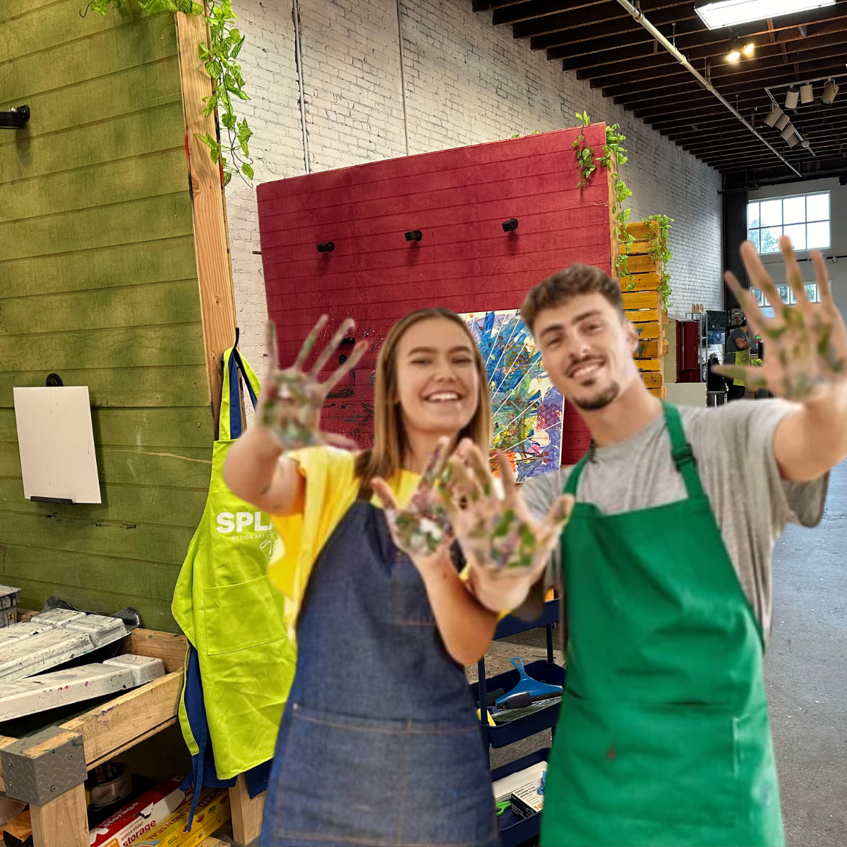 man & woman posing with paint on their hands