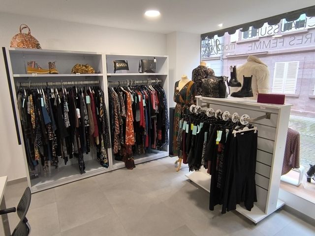 Un magasin de vêtements avec beaucoup de vêtements suspendus sur des portants.
