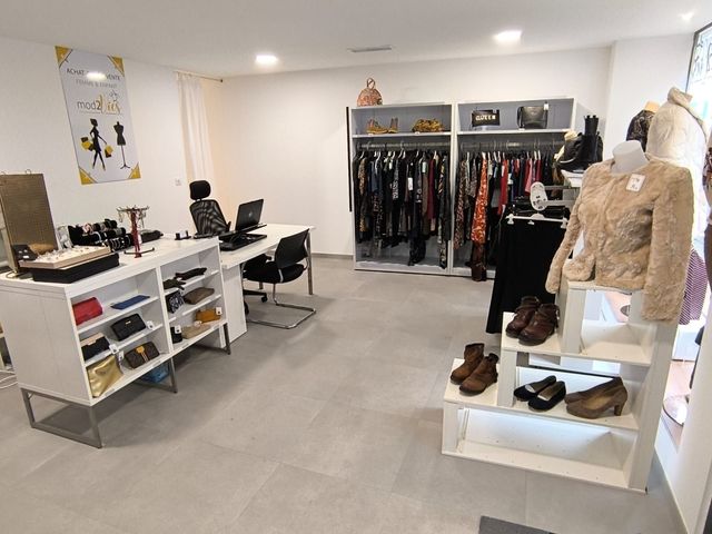 Un magasin avec beaucoup de vêtements et de chaussures exposés.