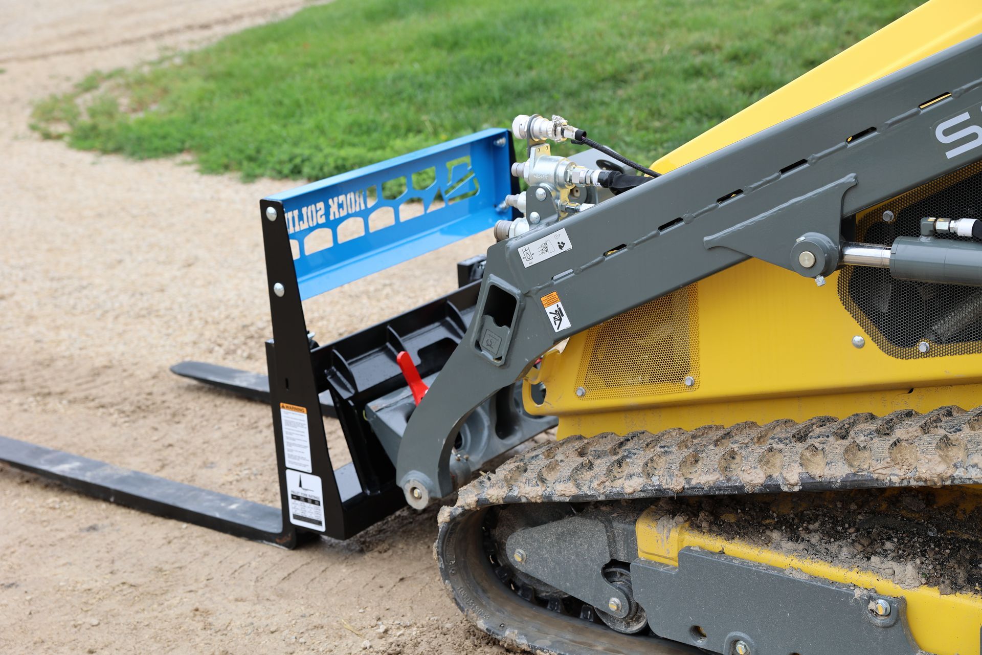 A yellow tractor with a forklift attached to it.