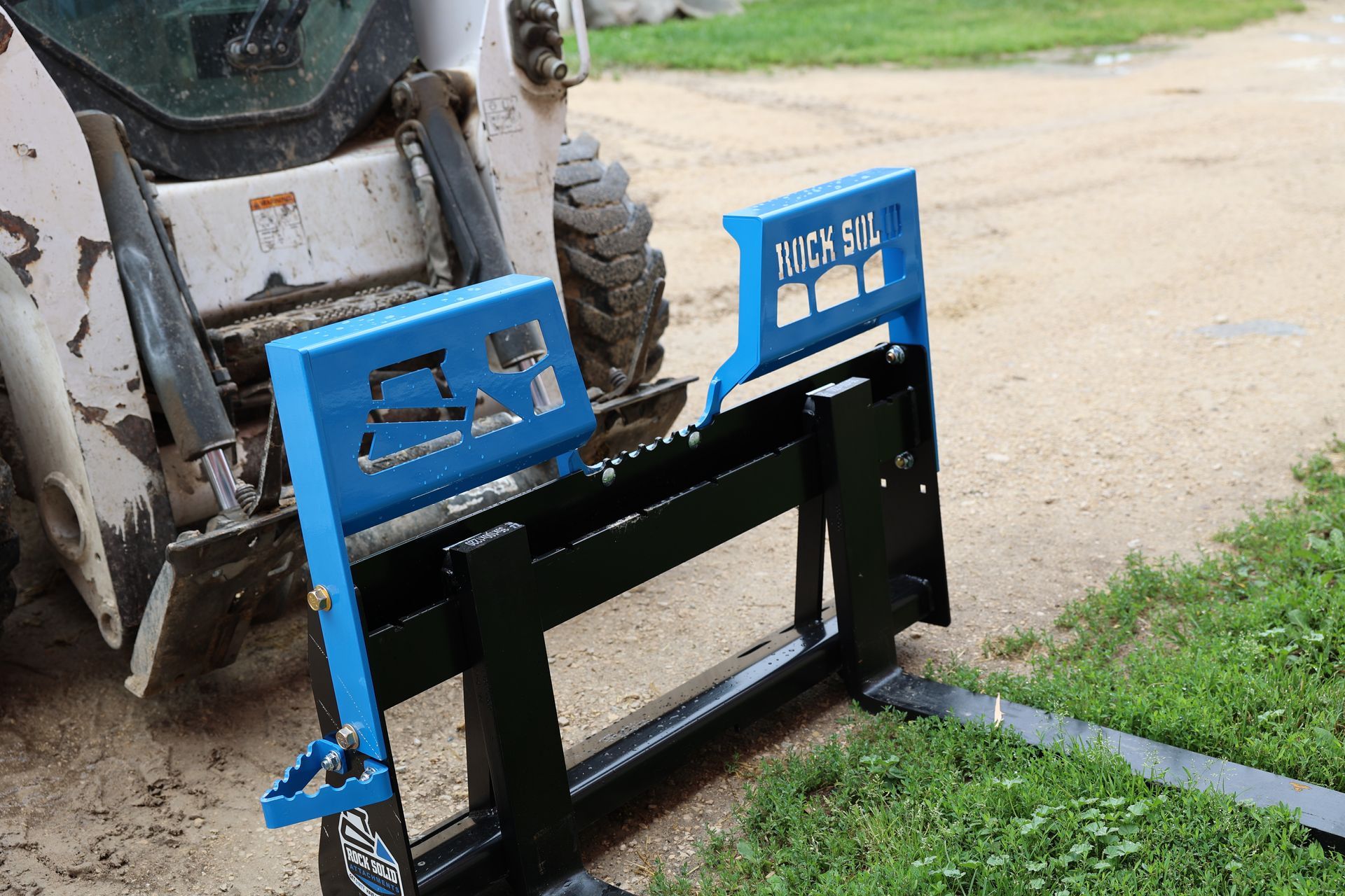 A forklift is attached to the back of a bulldozer.