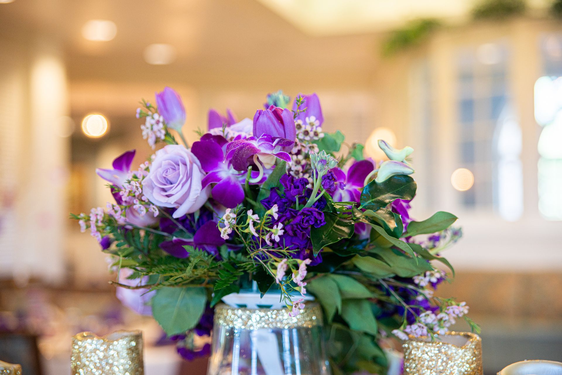 A vase filled with purple flowers is on a table.
