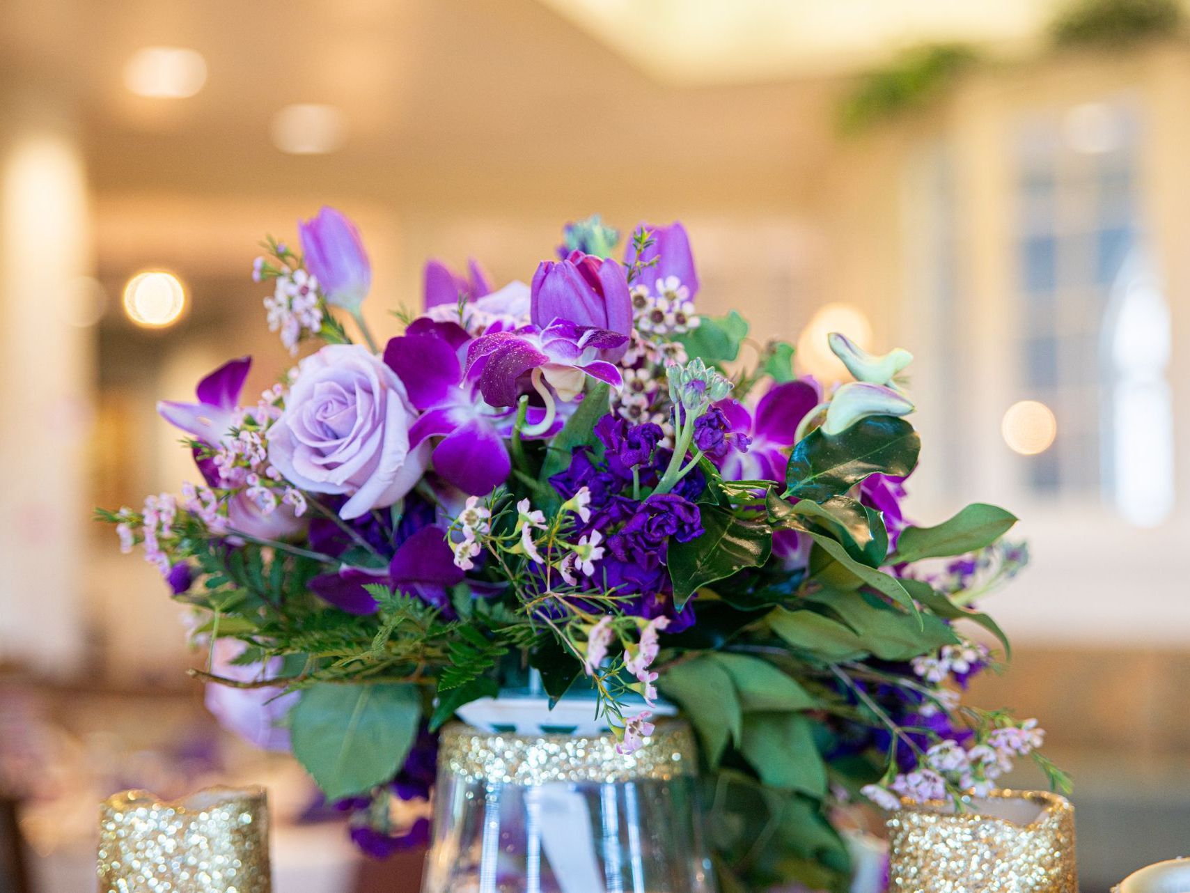 A vase filled with purple flowers is on a table.