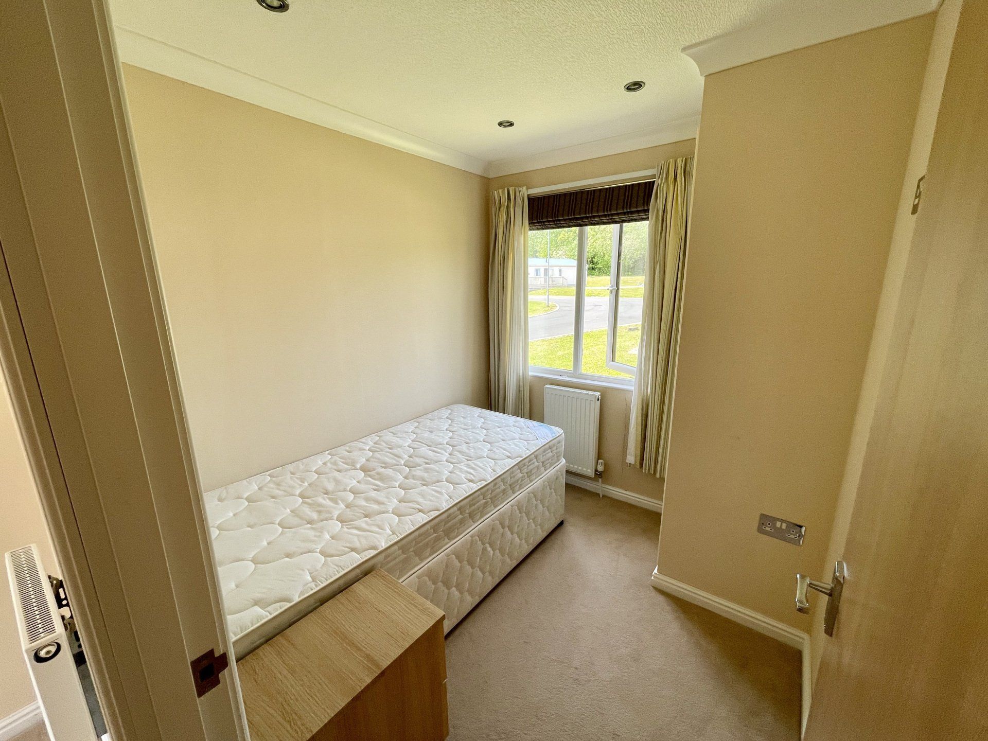A bedroom with a single bed and a window.