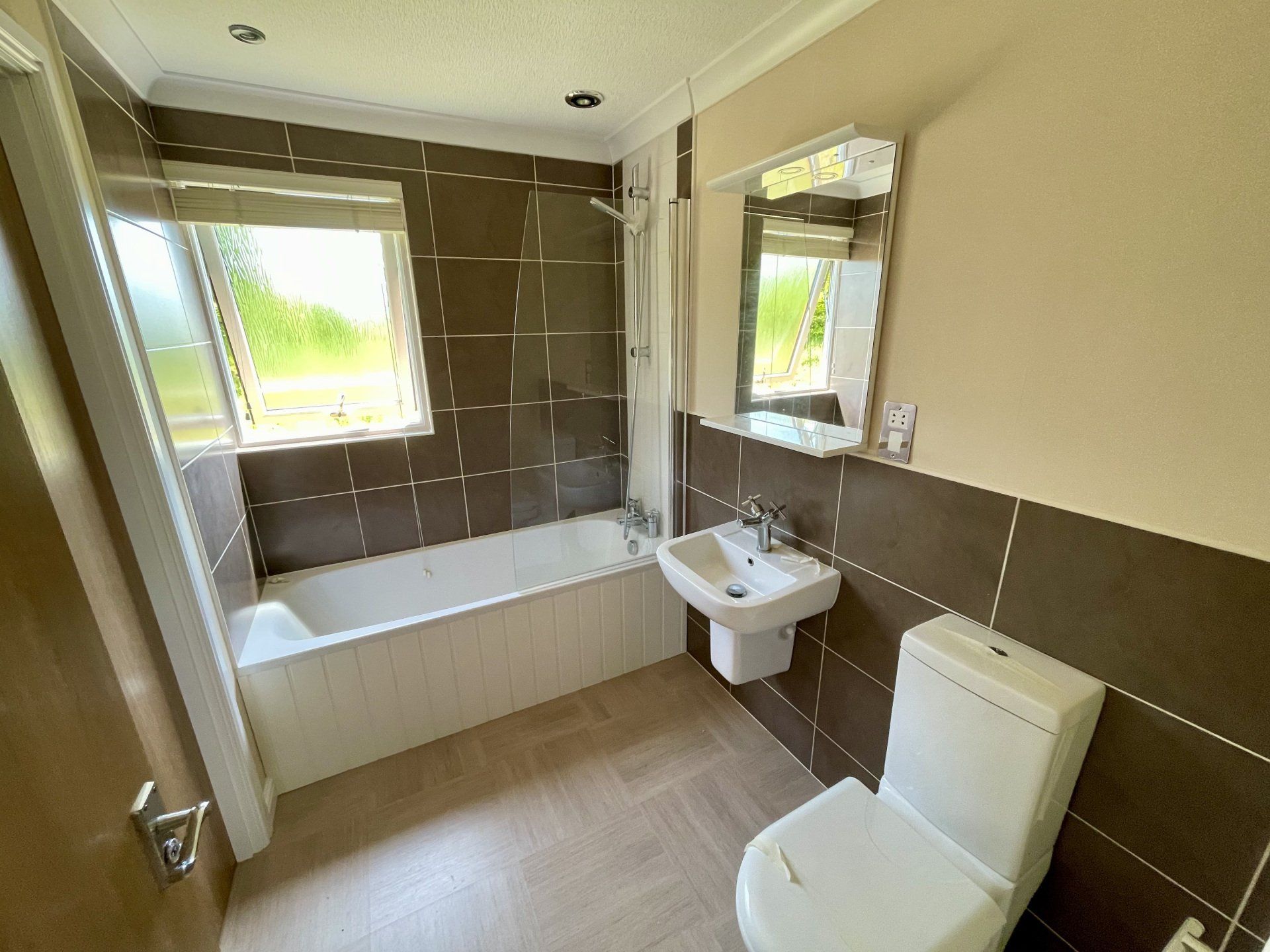 A bathroom with a toilet , sink and bathtub.