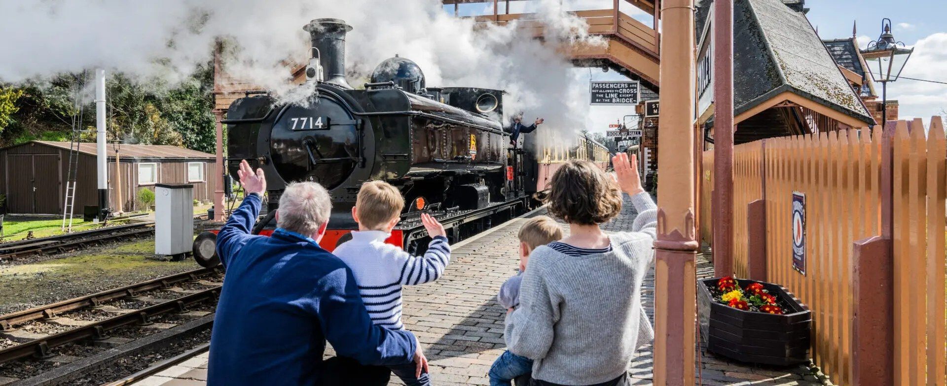 A group of people are standing on a train platform looking at a train.