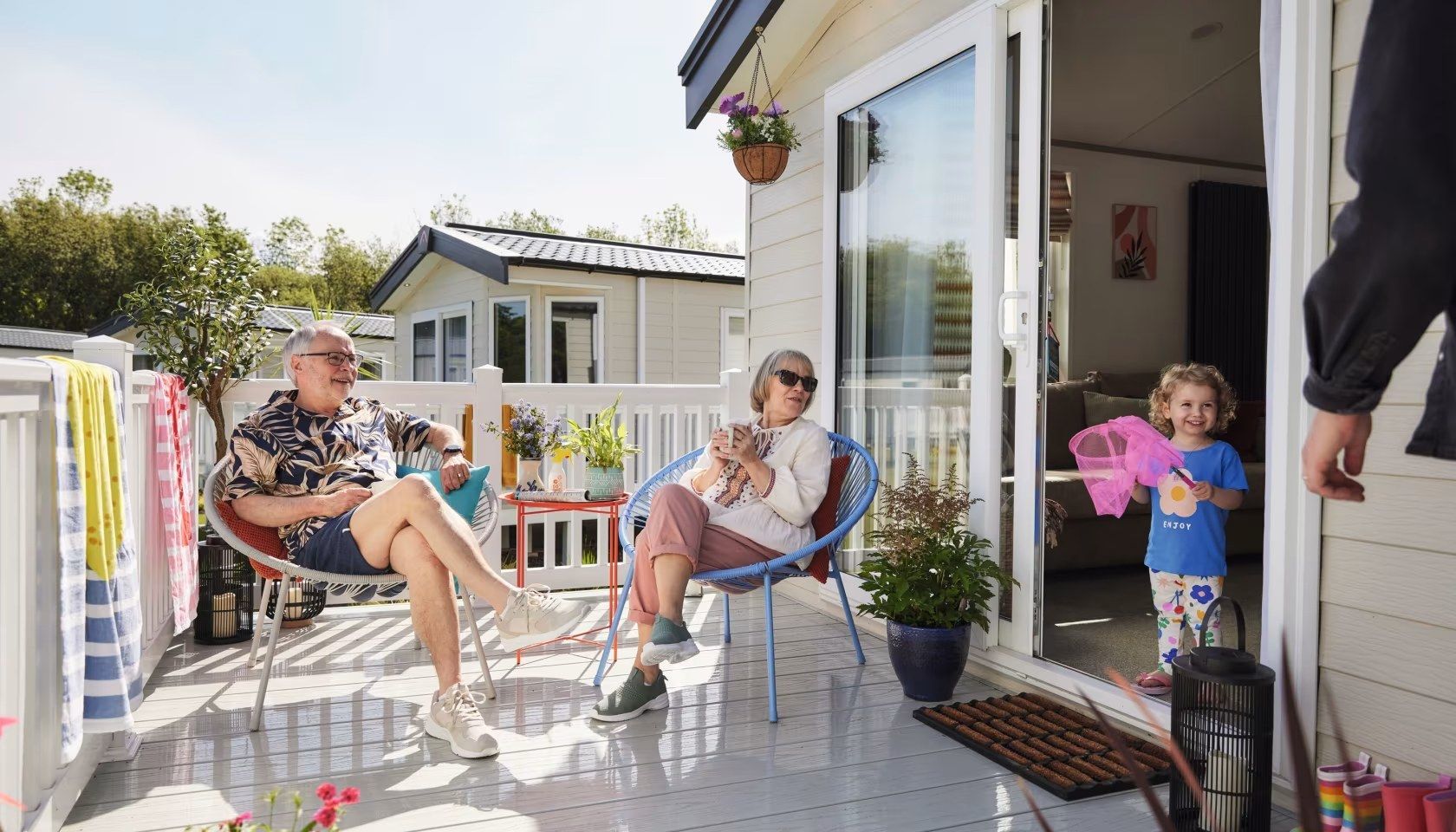 A family is sitting on a balcony in front of a house.