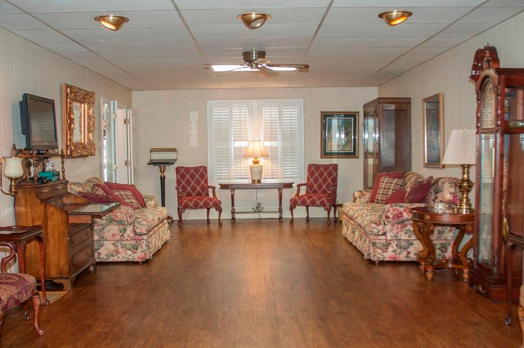Interior of a room with furniture, hardwood floors, and overhead lighting.