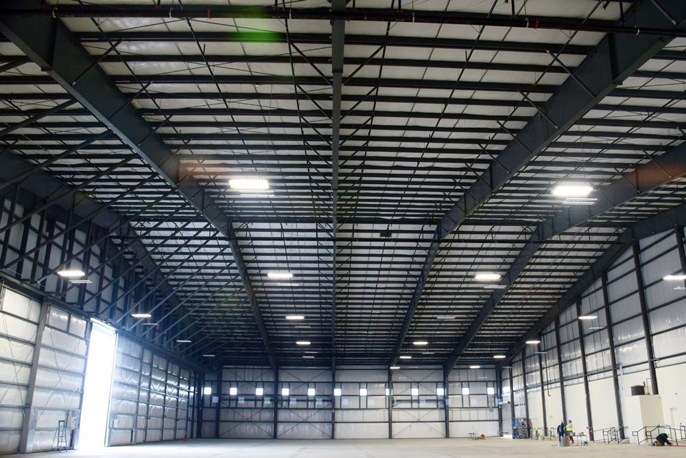 The inside of a large warehouse with a lot of lights on the ceiling.