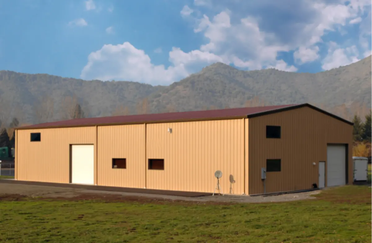 A large brown building with mountains in the background