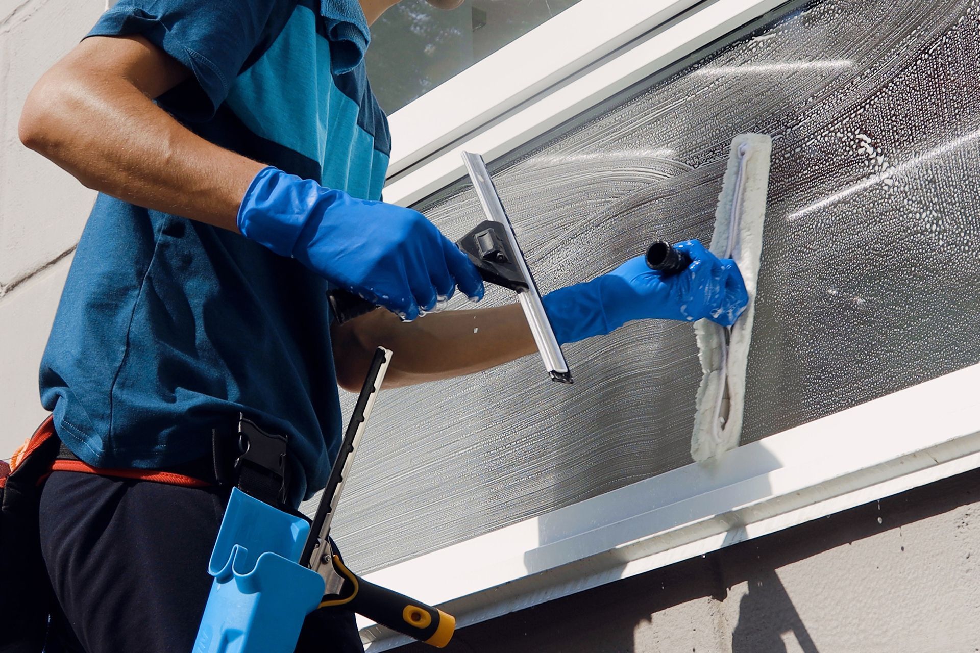 A man is cleaning a window with a squeegee.