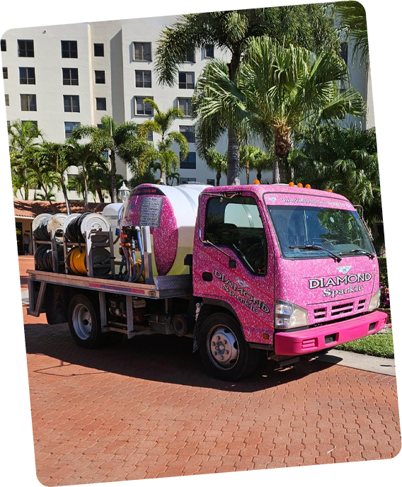 A pink truck is parked in front of a building