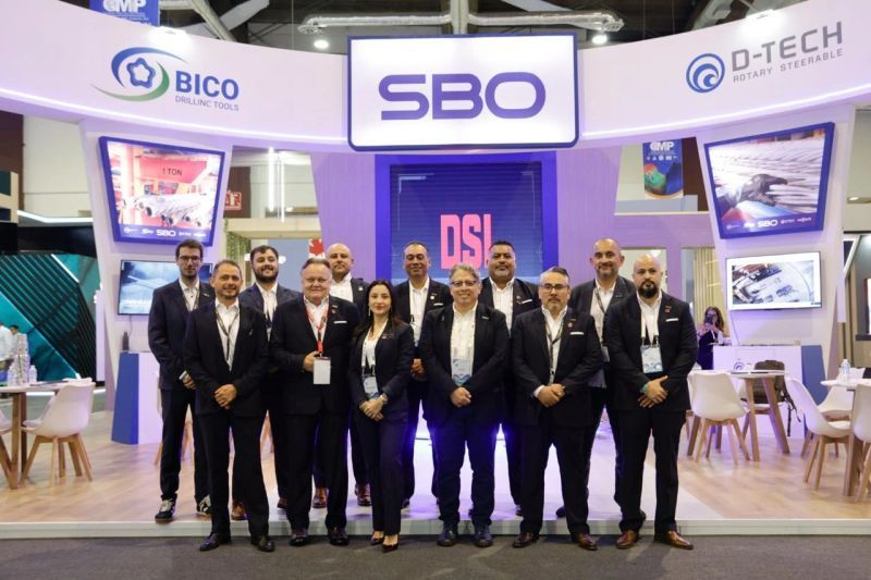 A group of people are posing for a picture in front of a sbo booth.