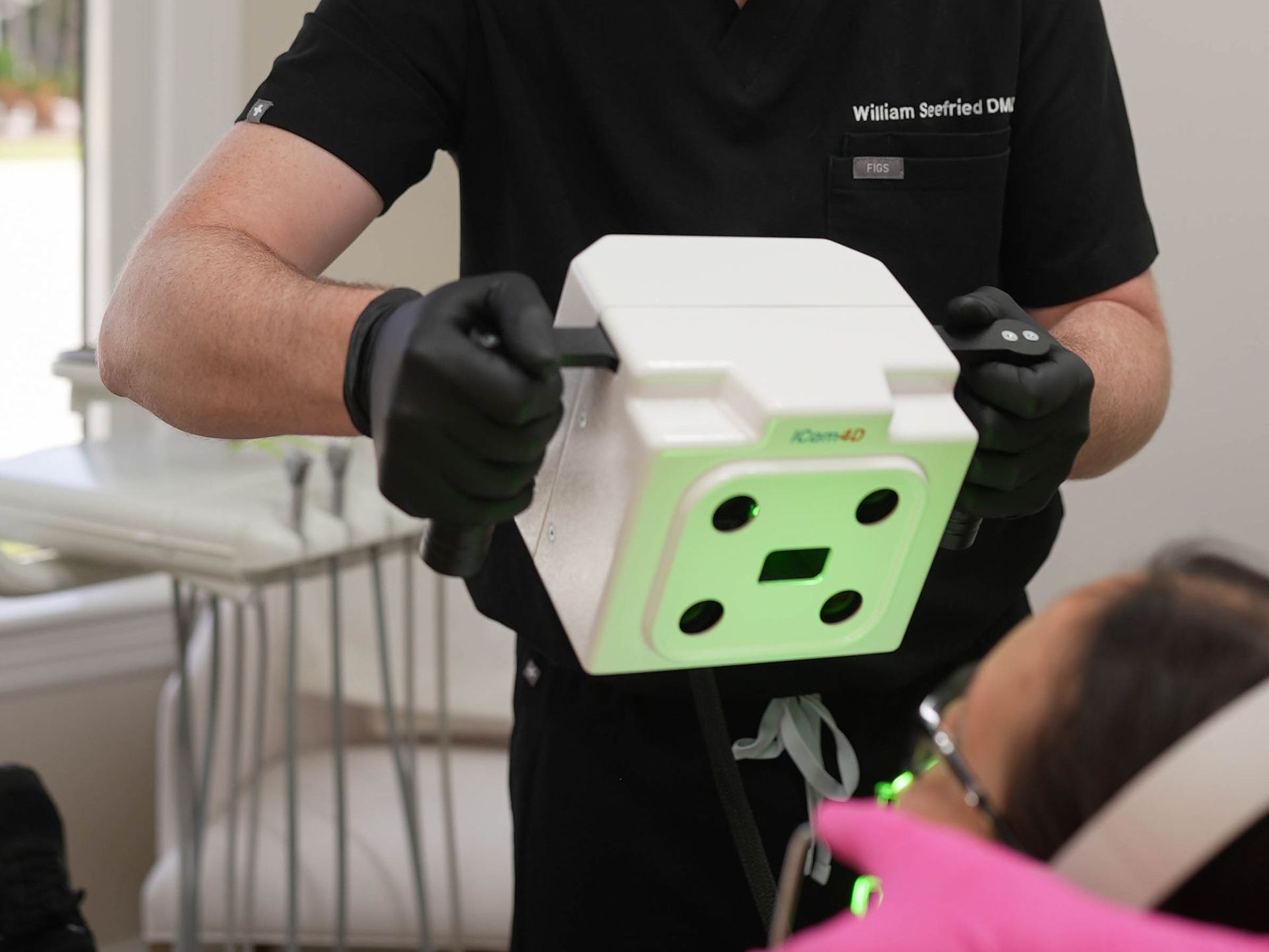 A dentist is holding a device that looks like an electrical outlet