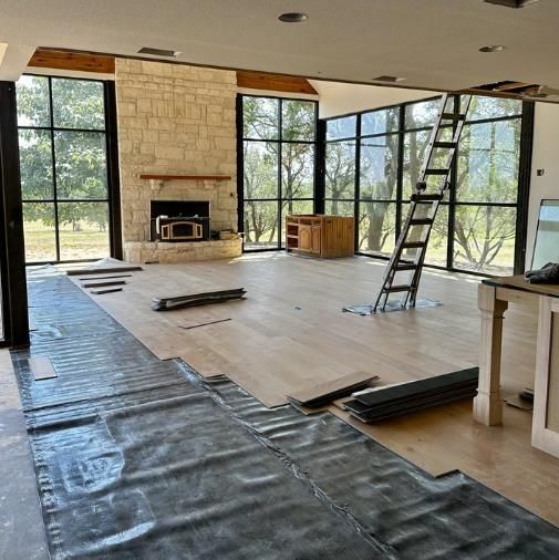 A living room with a fireplace and a ladder in it