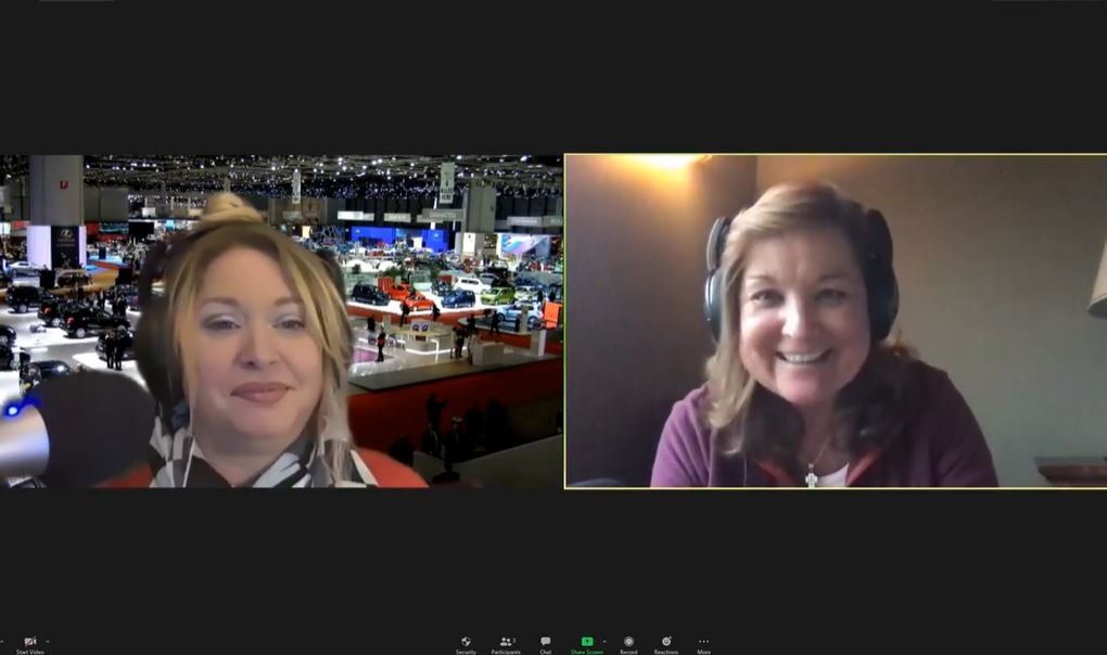 A video conference screenshot showing two people in a virtual meeting environment, representing conference attendance and participation