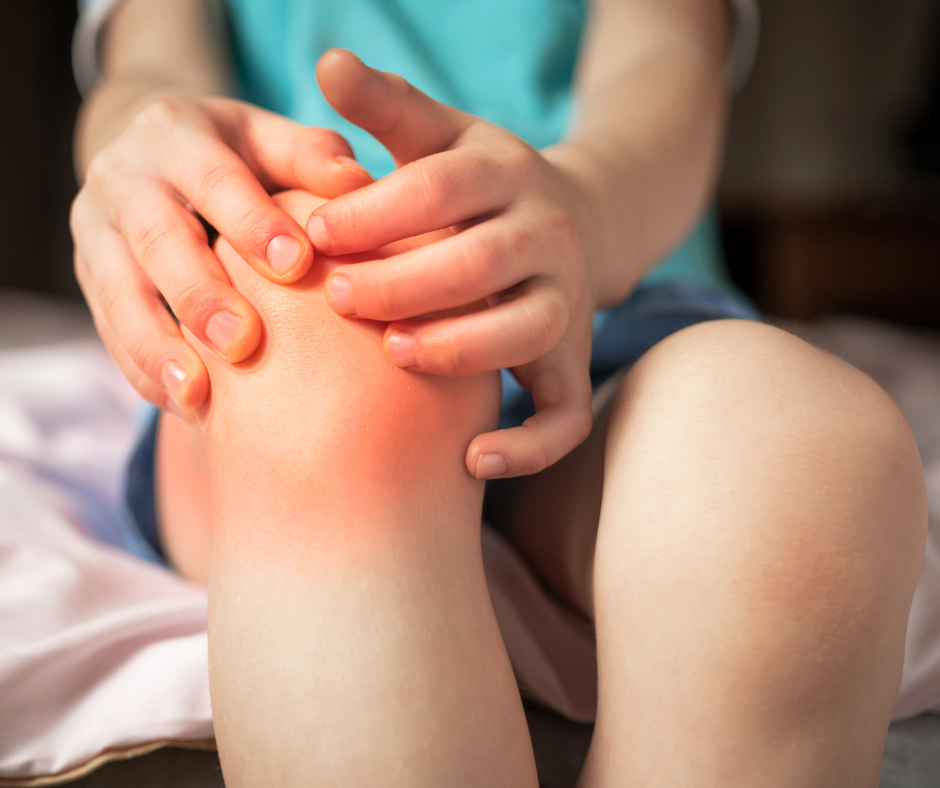 Child grabbing swollen red knee