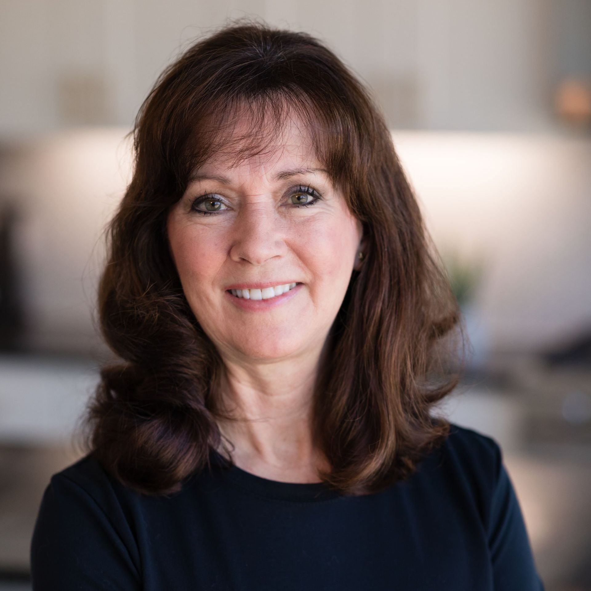 A woman in a black shirt is smiling for the camera.