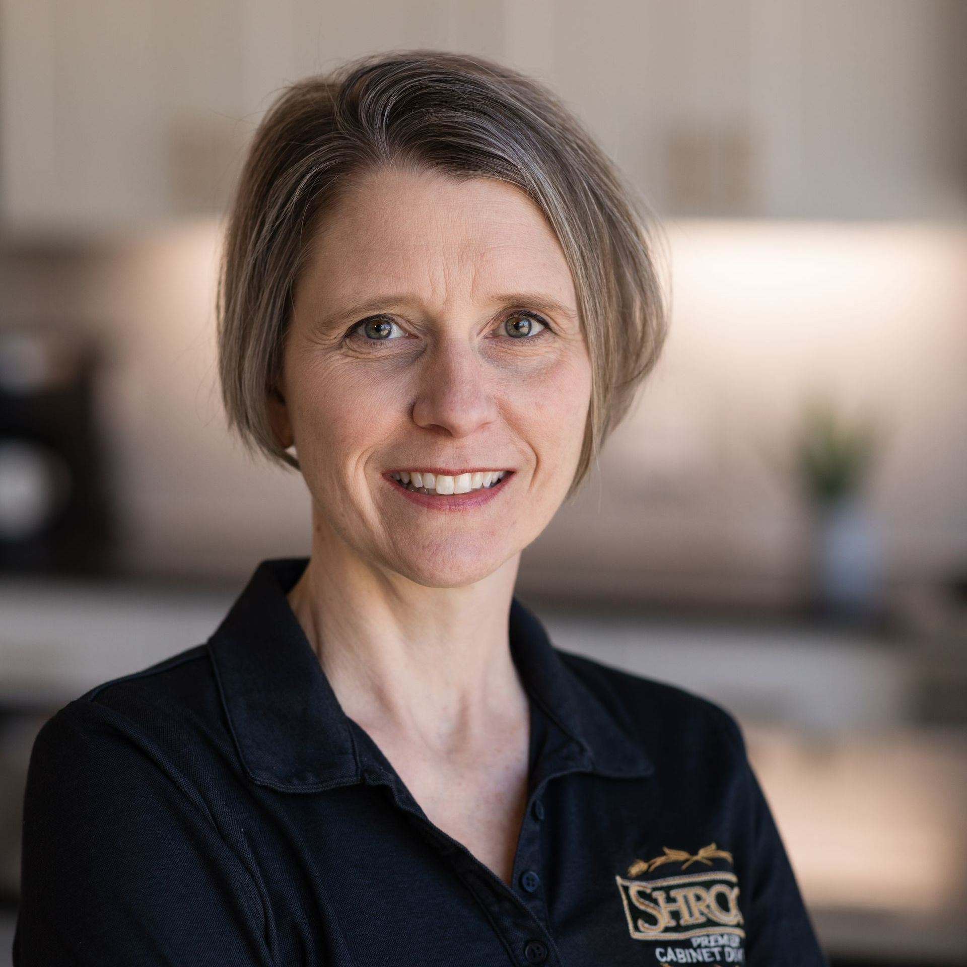 A woman in a black shirt is smiling for the camera.