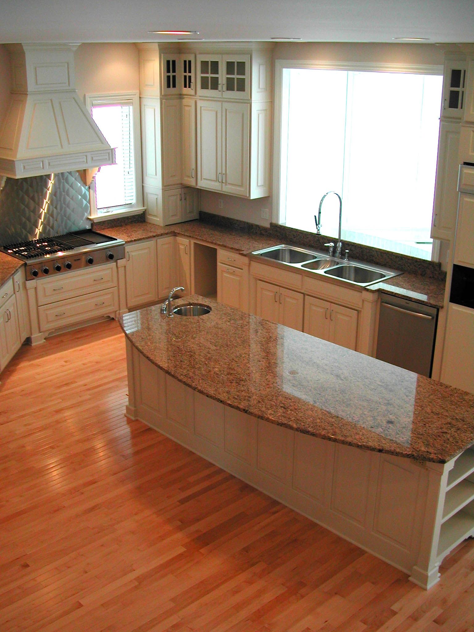 A kitchen with granite counter tops and hardwood floors