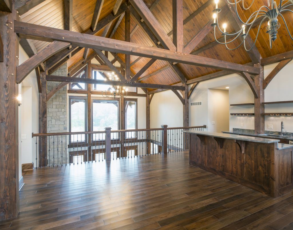 A large empty room with wooden beams and a chandelier.