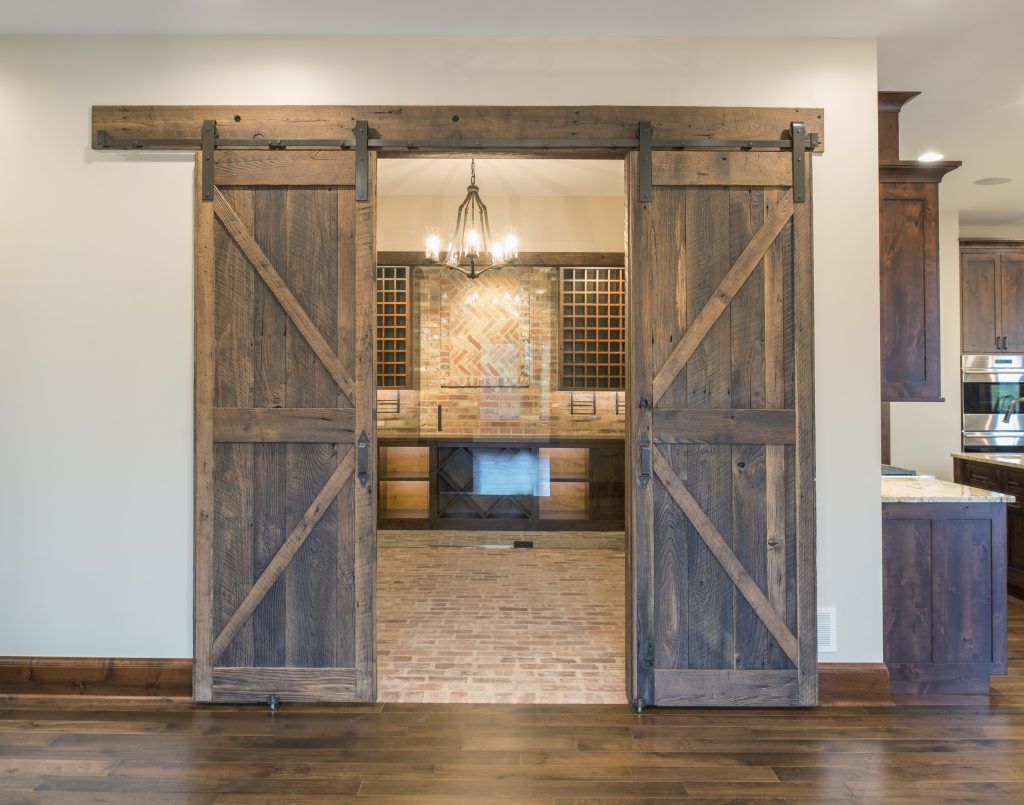 A kitchen with sliding barn doors leading to a bathroom.