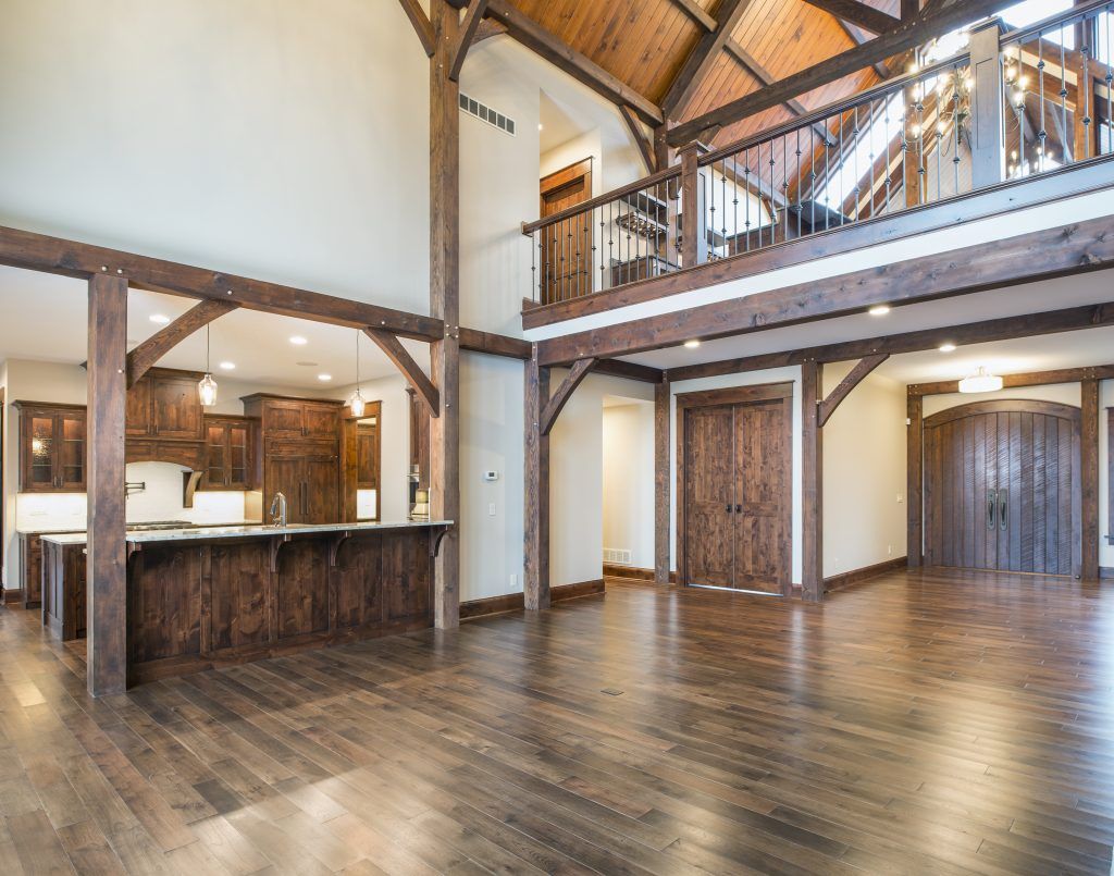 A large empty room with hardwood floors and a wooden ceiling.