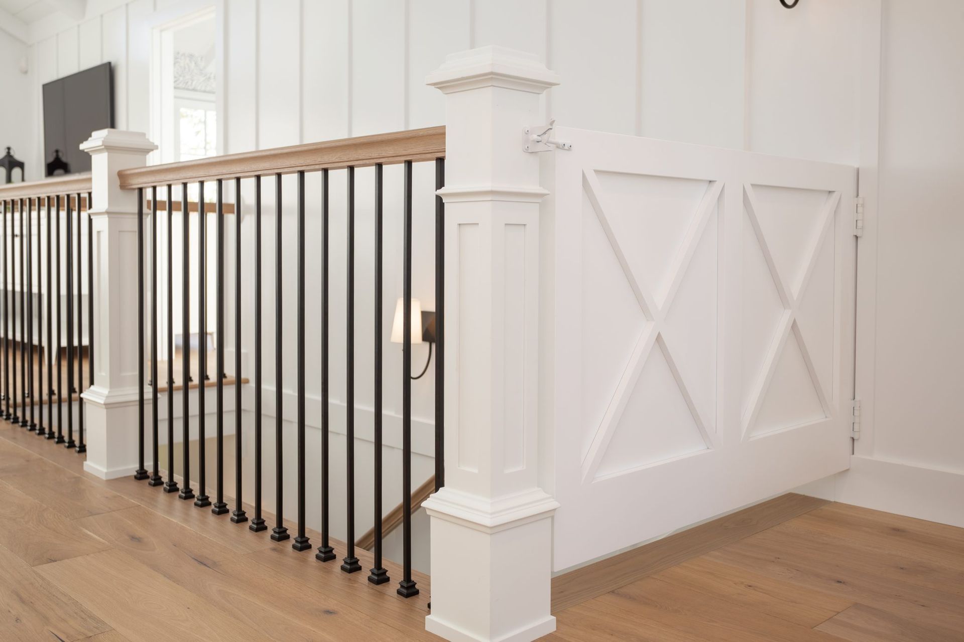 A staircase with a white railing and a black railing in a house.